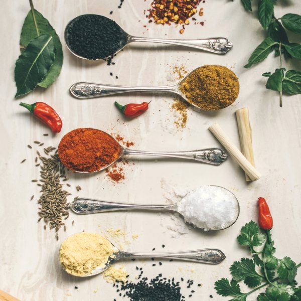 Turmeric, chilli and whole spices measured out on spoons